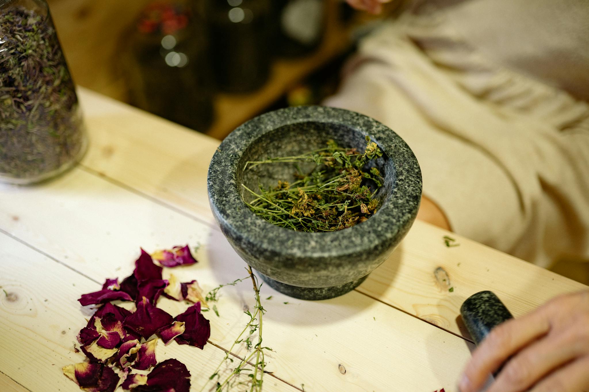 Close-up of dried herbs in a mortar and pestle for natural healing.